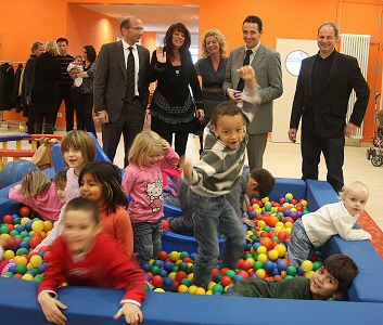 Gruppenbild mit spielenden Kindern während der Einweihung des sanierten Familienzentrums Tausendfüßler